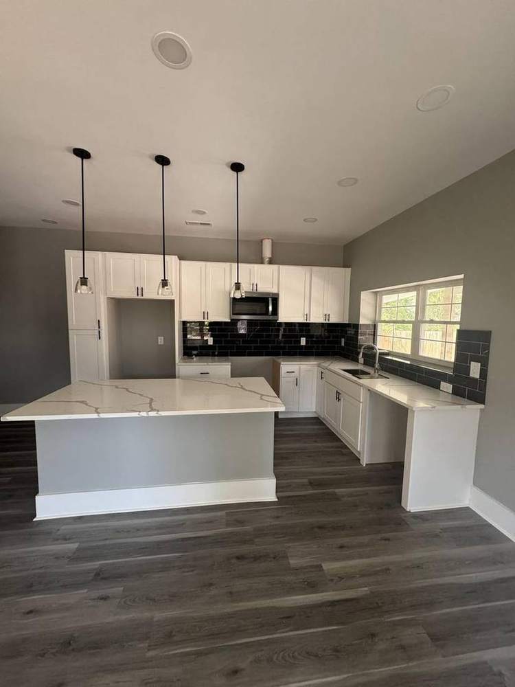 Finished kitchen with quartz island and pendant lights
