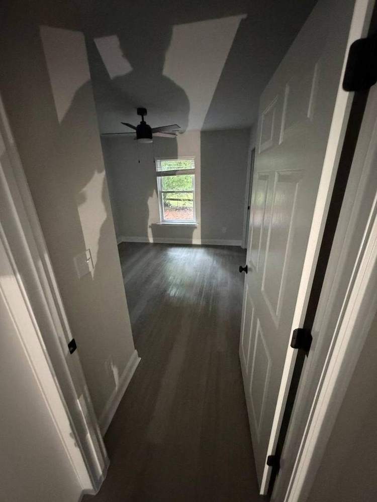 Finished bedroom with ceiling fan and new flooring