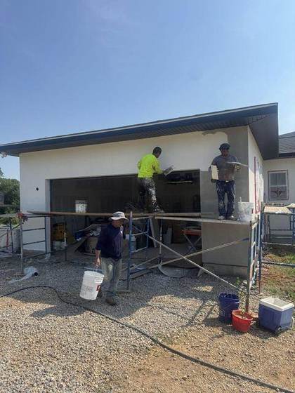 Crew applying stucco on the garage wall