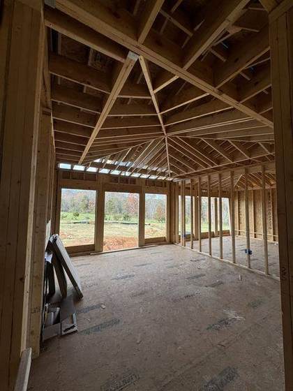 Vaulted living room ceiling framed, looking out to the pasture